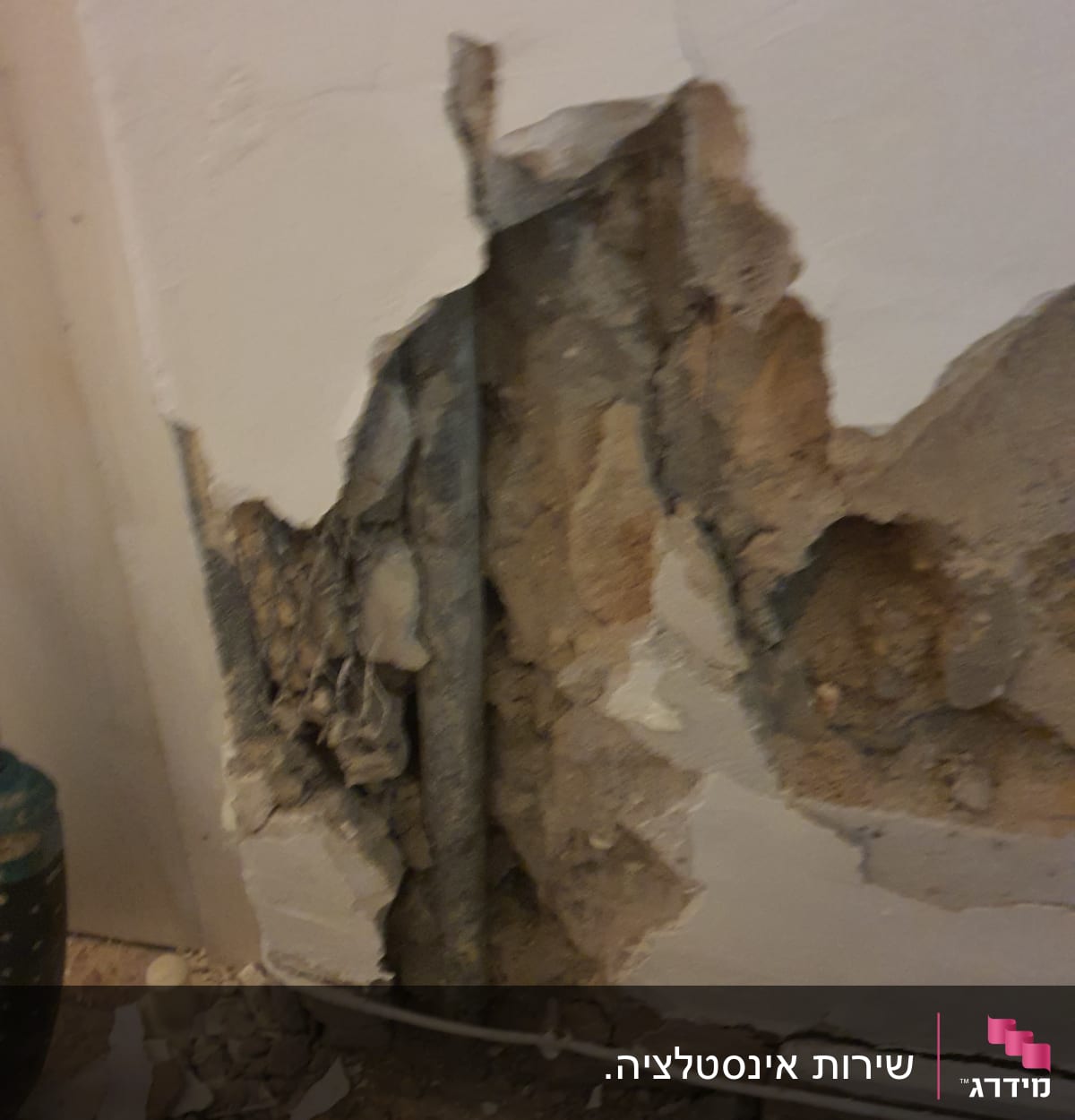 קיר שבור עם צינור חשוף ועבודות תיקון